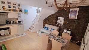 A compact kitchen with a microwave, coffee maker, and oven. A dining area with a table and chairs is adjacent to the kitchen. - House with character of  a fisherman (Collioure)