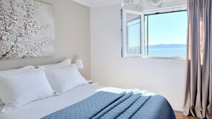 A bedroom with a bed, a large window, and a view of the sea. - Villa Vedran - A Peaceful Retreat with Stunning Sea Views in Podgora (Podgora)