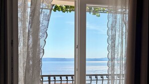 A balcony with a table and chairs, overlooking a body of water. - Villa Vedran - A Peaceful Retreat with Stunning Sea Views in Podgora (Podgora)