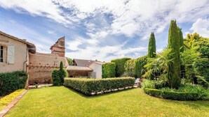 A well-maintained garden with a variety of plants and a traditional building with a tiled roof. - Maison Augustine – In the heart of Lisle-sur-Tarn (Lisle-Sur-Tarn)