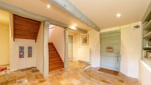 A spacious hallway with a wooden staircase, stone flooring, and a rustic door. - Maison Augustine – In the heart of Lisle-sur-Tarn (Lisle-Sur-Tarn)
