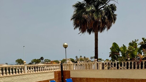 A swimming pool with blue tiles, surrounded by a white balustrade and blue lounge chairs. - Villa with Private Pool and Large Underbuild (Gran Alacant)