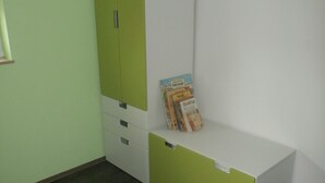 A room with a green and white wardrobe, a small white desk, and a few books on the desk. - Comfortable child-friendly holiday apartment, Baltic Sea, Usedom, beach, fishing (Peenemünde)