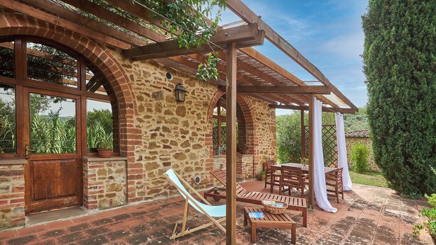 A stone building with a wooden pergola, outdoor seating, and a hammock. - Apartment in Torrita, ground floor, terrace with view, swimming pool, 4 people (Torrita di Siena)