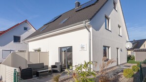 A modern two-story house with a sloped roof, solar panels, and a sign indicating a well-maintained property. - Holiday home on the Baltic Sea - up to 6 persons (4 stars) (Zierow)