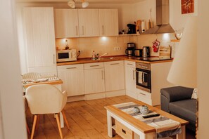 A compact kitchen with white cabinets, a microwave, a coffee maker, and a toaster. - Marie Vacation Apartment in Bergen auf Rügen, Quiet Location (Bergen auf Rügen)