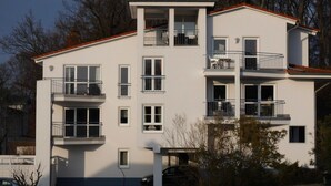 En byggnad med flera våningar, balkonger, stora fönster och ett platt tak.