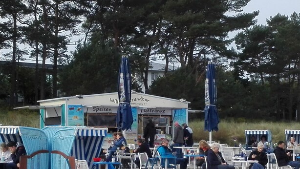 En restaurang vid stranden med uteservering och parasoller.
