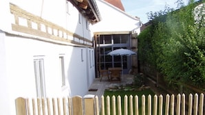 A white building with a wooden fence in front. - Living in the listed house like grandma without having to compromise on comfort (Schernfeld)
