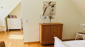 A bedroom with a wooden floor, a white bed, a wooden cabinet, a desk, a chair, and a lamp. - Great facilities! Close to town! Calm! (Oldenburg)