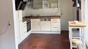 A kitchen with white cabinets, a wooden countertop, and a tiled floor. - Great facilities! Close to town! Calm! (Oldenburg)