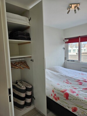 A bedroom with a bed, a wardrobe, and a window.