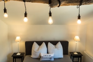 A bedroom with a bed, pillows, and bedside lamps.