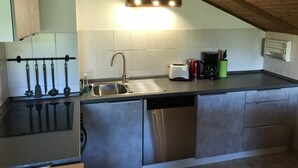 A modern kitchen with a stainless steel sink, a dishwasher, and a coffee maker. - Charming vacation rental in a secluded location with a wonderful view (Bayerniederhofen)