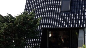 Un edificio moderno con techo inclinado y una ventana pequeña.