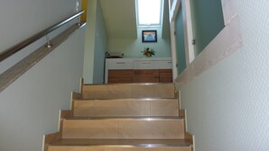 Un escalier menant à un palier doté d’une fenêtre et d’un placard.