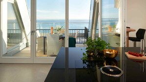 Une chambre moderne dotée d’une porte vitrée donnant sur un balcon avec vue sur la mer.