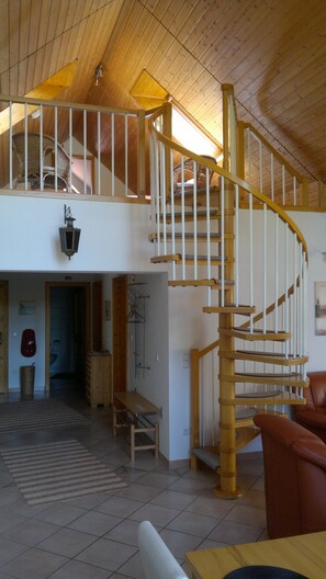 A spacious loft with a wooden staircase, a high ceiling, and a view of the upper floor. - beautiful apartment in the country, exclusive furniture (Wolfersdorf)