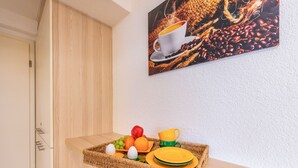 A breakfast tray with fruits, eggs, and plates on a wooden shelf in a hotel room.
