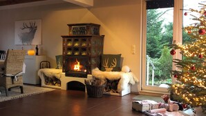 Ein gemütliches Wohnzimmer mit Kamin, Weihnachtsbaum und Bücherregal.