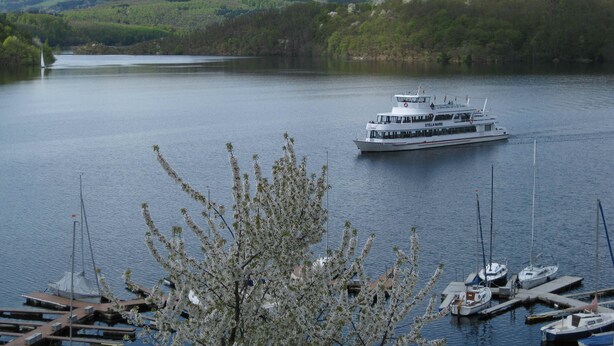 Ein Fluss mit einer Fähre namens "Stella Maris" und einem Steg mit Booten.