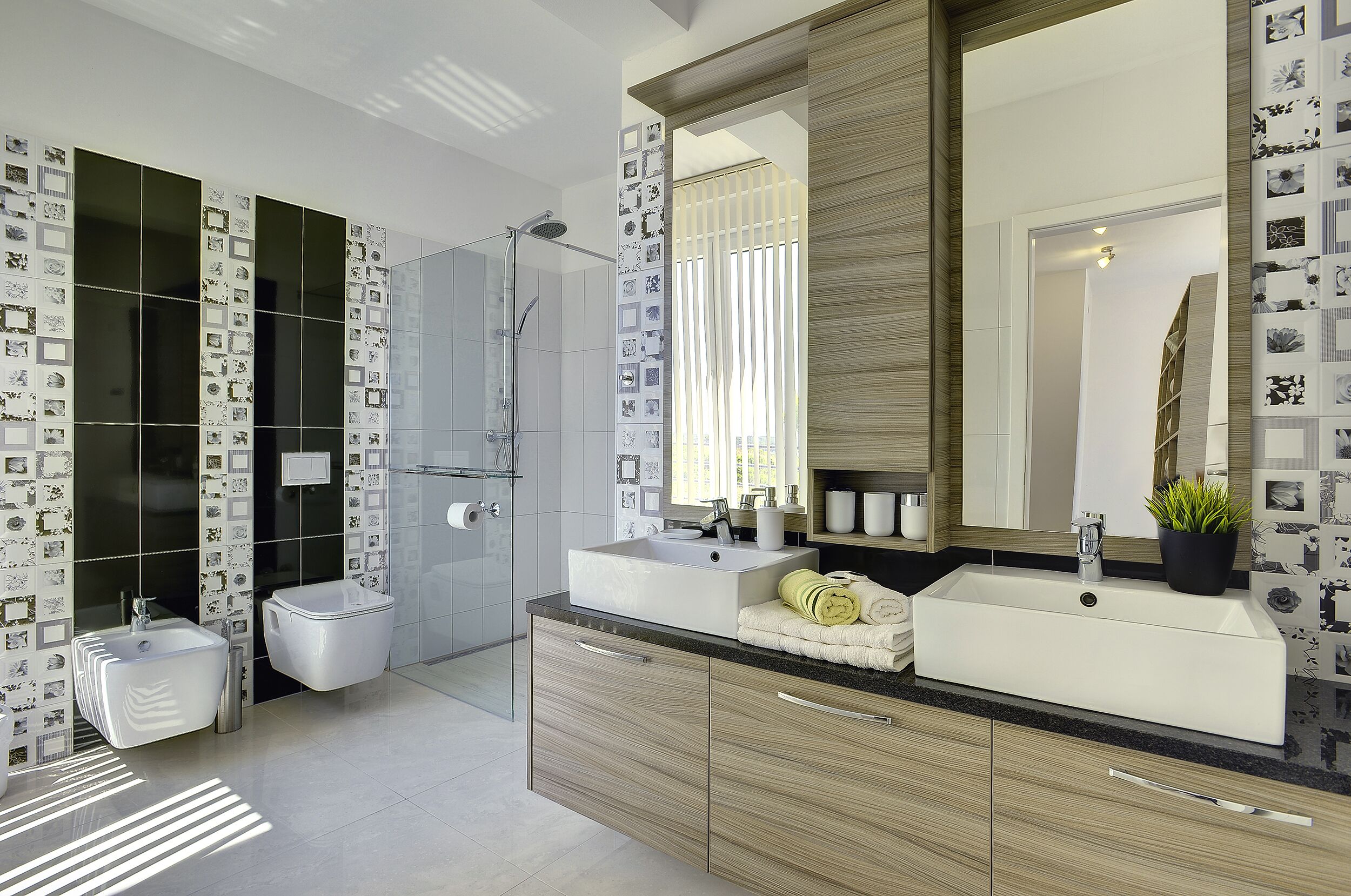 A modern bathroom with a large mirror, two sinks, a shower, and a toilet.