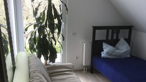 Una habitación con cama, ventana y vistas a zonas verdes, además de un radiador.