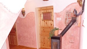 Ein gemütliches Zimmer mit Holztür, Kamin und einer Topfpflanze.