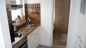 A compact kitchen with wooden countertops, a stainless steel sink, and a built-in oven. - family-friendly, comfortable accommodation, 2 terraces, 200 m to the beach (Neustadt in Holstein)