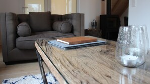 Uma sala de estar aconchegante com um sofá, uma mesa de vidro e um livro.