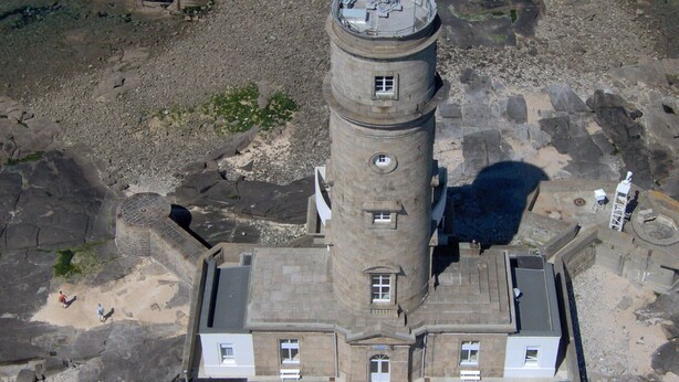 Ein steinerner Turm mit einer kreisförmigen Aussichtsplattform, einem zentralen Eingang und einem umgebenden Innenhof.