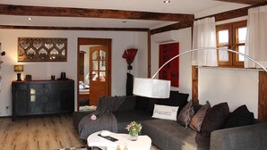 Un salon chaleureux avec un canapé, une table basse et un miroir décoratif.
