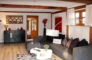Een gezellige woonkamer met een bank, een salontafel en een lamp.