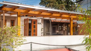 Un bâtiment doté d’une pergola en bois, d’un toit rouge et d’une enseigne indiquant le nombre de chambres.