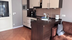 A compact kitchen with a microwave, stove, and sink.