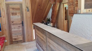 Ein Holzinterieur mit einer Rezeption, einer Tür und einem Fliesenboden.