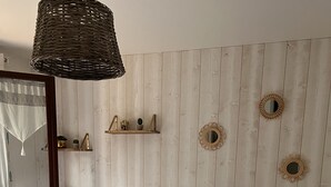 Een keurig opgemaakt slaapkamer met een bed, nachtkastjes, een lamp en decoratieve spiegelwand.