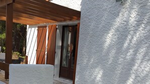 Een terras met twee loungestoelen en een pergola.