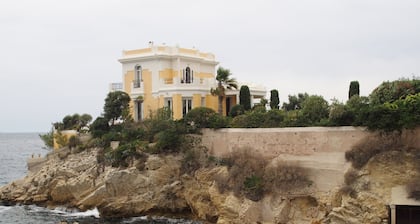 A balcony over the sea. A room in town