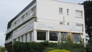 Un edificio blanco con balcones y un letrero que dice 'Residence Les Côtes d'Armor'.