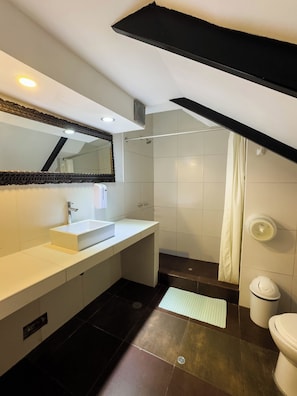A modern bathroom with a white sink, mirror, and shower.