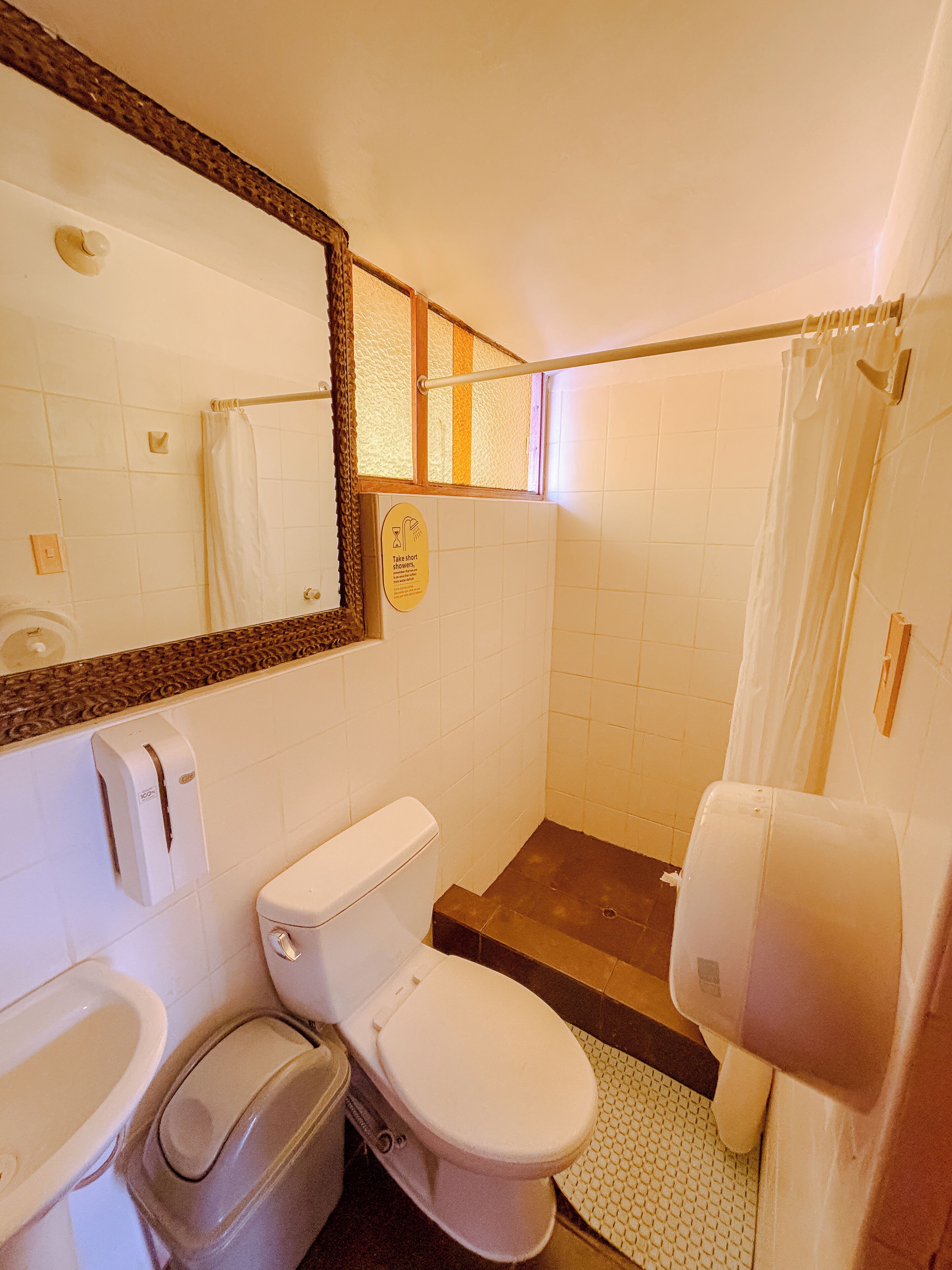 A bathroom with a toilet, sink, and shower.