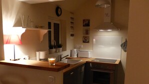 Une cuisine de taille réduite, équipée d’un évier, d’une cuisinière et d’un petit plan de travail.