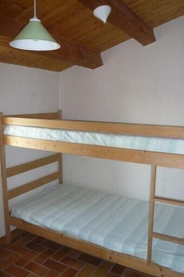 A bunk bed with a green light fixture above it.