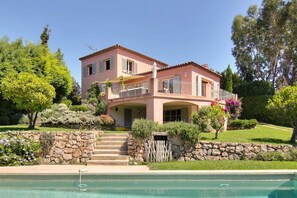 A two-story house with a stone staircase leading to a pool. - Charming villa with pool and sea view, ideal for family or friends (Vallauris)