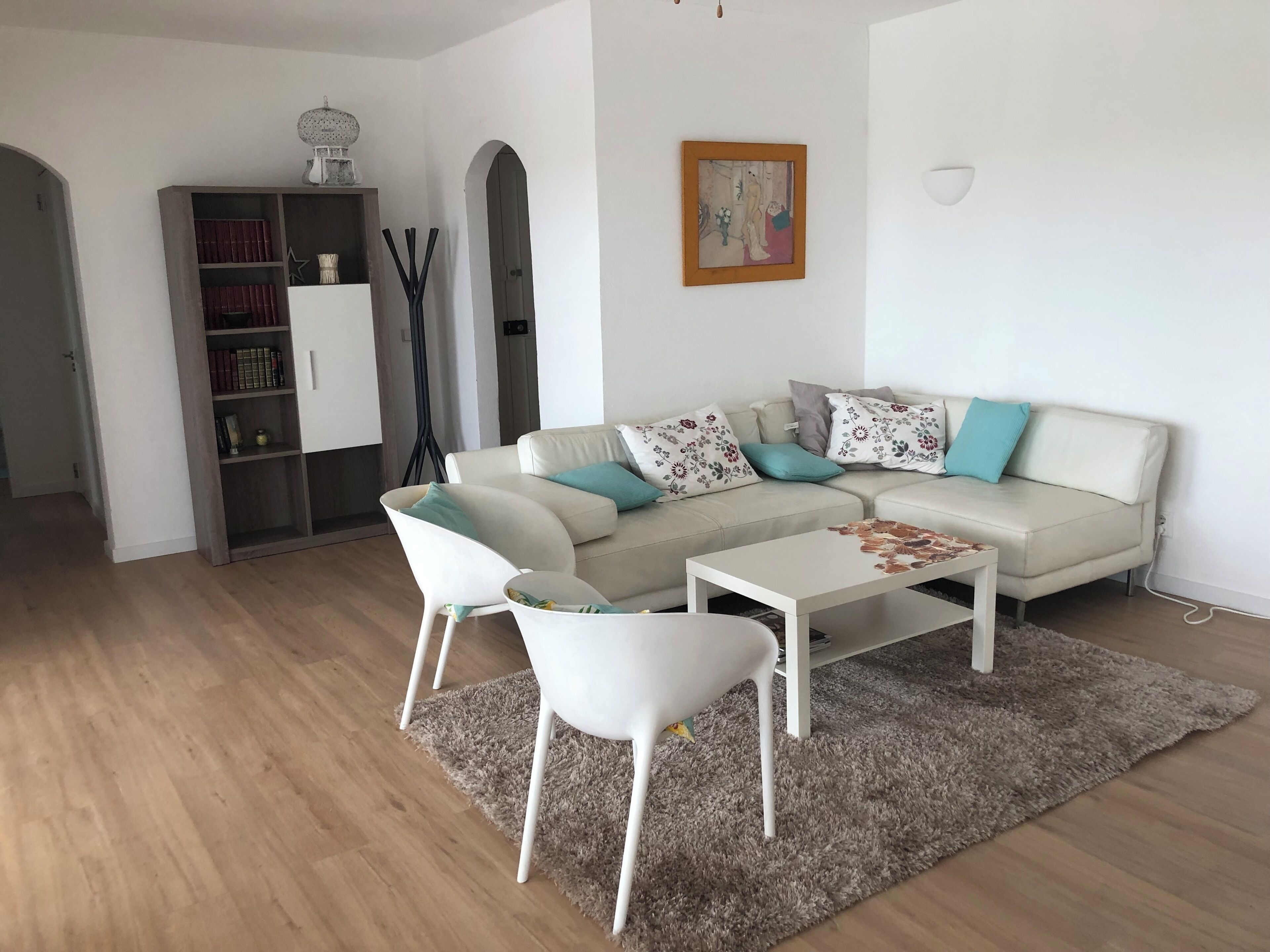 Een moderne woonkamer met een bank, een salontafel en een boekenplank.