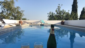 A poolside setting with a bottle of champagne, two glasses, and a bowl of chips. - beautiful villa with private pool, bbq, wifi, 10 mins from the sea and  golf  (alcantarilha)
