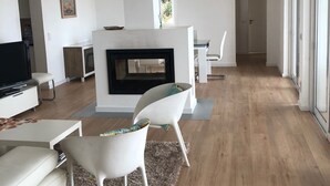 A modern living room with a fireplace, white furniture, and a large window. - beautiful villa with private pool, bbq, wifi, 10 mins from the sea and  golf  (alcantarilha)