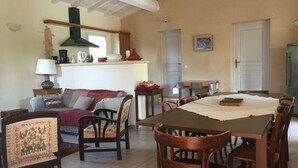 Ein gemütliches Wohnzimmer mit Essbereich, Holzmöbeln und einer Küche im Hintergrund.