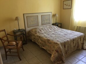 A bedroom with a bed, a chair, two bedside tables, and a framed picture on the wall. - Country cottage with swimming pool, for 8 people, fully equipped (Pont-Saint-Esprit)